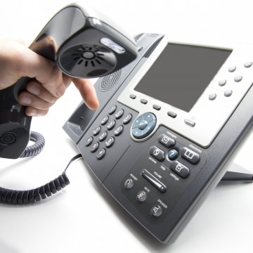 cost pricing axvoice voip service hand holding voip phone dialing making phone call 